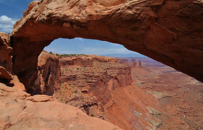 From the Mesa Arch Trail, enjoy spectacular views over the red Canyonlands