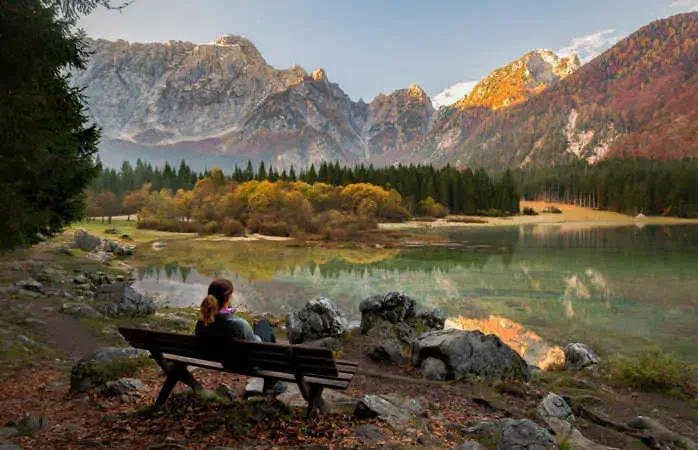 Young female is enjoying autumn colors at Laghi di Fusine in Italy; Shutterstock ID 776290393