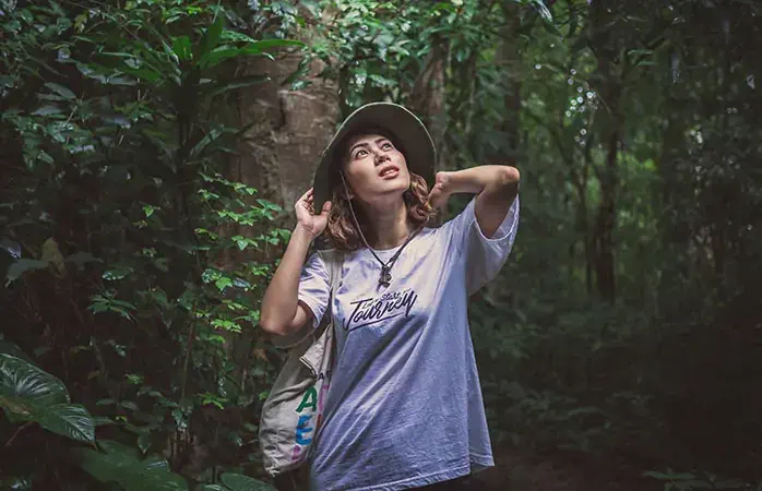 Beauty asian woman traveller wearing white shirt and green bucket hat holding canvas tote bag enjoying view in green forest.; Shutterstock ID 1214964994; Purpose: Plastic free travel tips; Brand (KAYAK, Momondo, Any): momondo